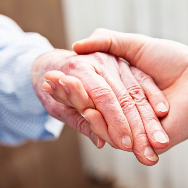 Care, the image of carer and service user holding hands, dignity in Care